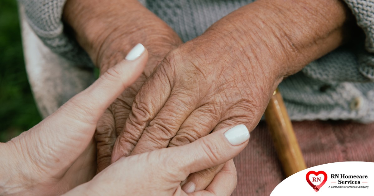 A caregiver holding an older adult's hands represents the support that hospice care can bring.