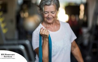 An older woman uses a resistance band to exercise, representing how staying active can help older adults keep their blood pressure in a healthy range.