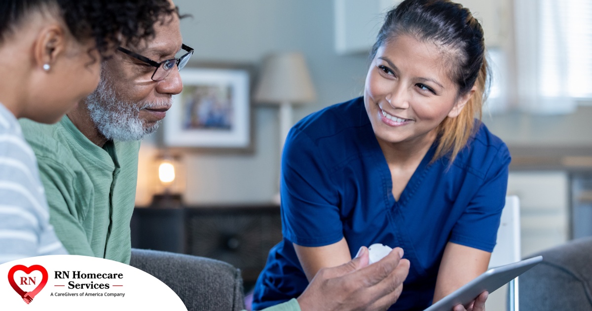 A nurse smiles as she helps an older couple with their medication in the comfort of their own home, showing the benefits of in-home nursing services.